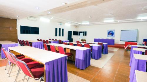 a conference room with tables and chairs and a screen at Lembah Gunung Kujang by ARBA in Gunungtua