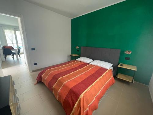 a bedroom with a bed and a green wall at Schöne Ferienwohnung mit herrlichem Seeblick in Tignale