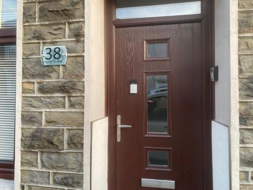 a wooden door with a sign on a brick building at Beautiful Views Welsh Retreat 2bedroom in Mountain Ash