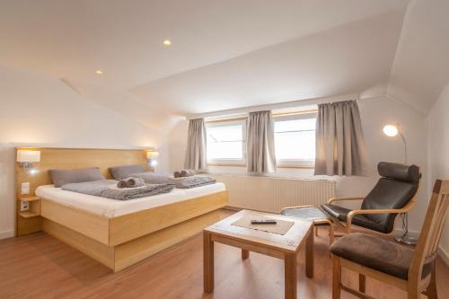 a hotel room with a bed and a chair at Ferienhaus DÖRING in Langeoog