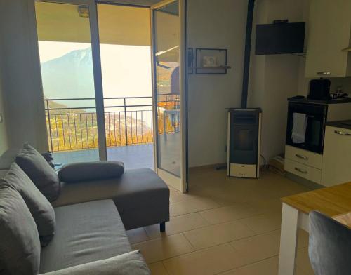 a living room with a couch and a large window at Schöne Ferienwohnung mit herrlichem Seeblick in Tignale
