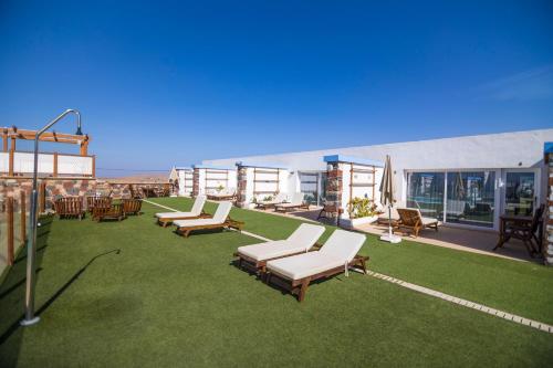 a patio with lounge chairs and tables on a roof at Hotel Rural Rosario Martin in Puerto del Rosario