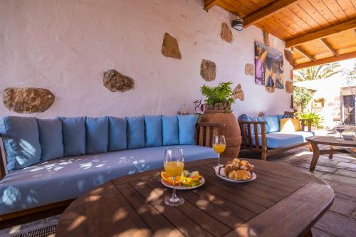 a living room with a blue couch and a table at Hotel Rural Rosario Martin in Puerto del Rosario