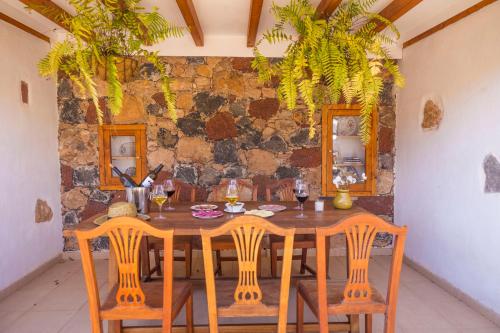 a dining room with a wooden table and chairs at Hotel Rural Rosario Martin in Puerto del Rosario