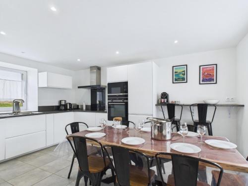 - une cuisine avec une table et des chaises en bois dans la chambre dans l'établissement Maison de campagne avec grand jardin pour 8, à Plouguerneau