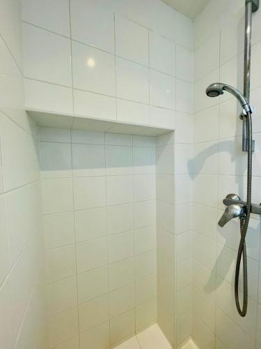 une douche avec pommeau de douche dans une salle de bain dans l'établissement Tour Eiffel Invalides Pierre Leroux, à Paris