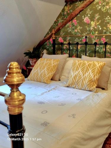 a bed with yellow and white sheets and pillows at Maison Maisy in Navarrenx