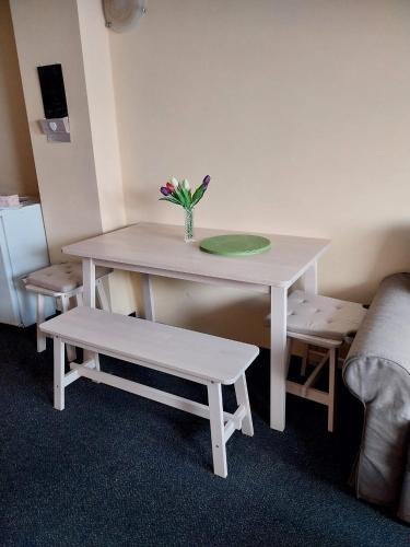 a table with a vase of flowers and a bench at Wellness apartmán Frymburk D403 Čtvrté patro in Frymburk
