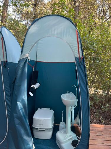 a tent with a toilet and a sink in it at Boschetto Natural Village in Monte San Giusto