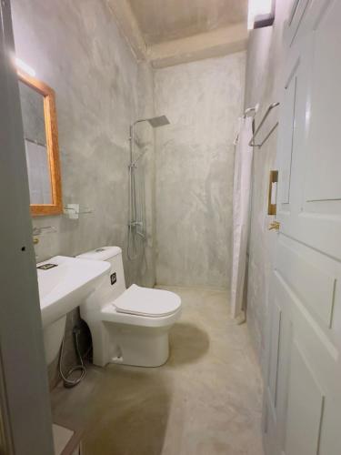 a white bathroom with a toilet and a sink at Onara Home Koggala in Habaraduwa