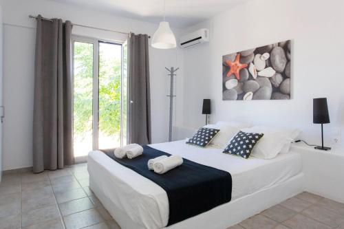 a bedroom with a large bed with towels on it at Kea Villa Thea by A&D Properties in Otzias