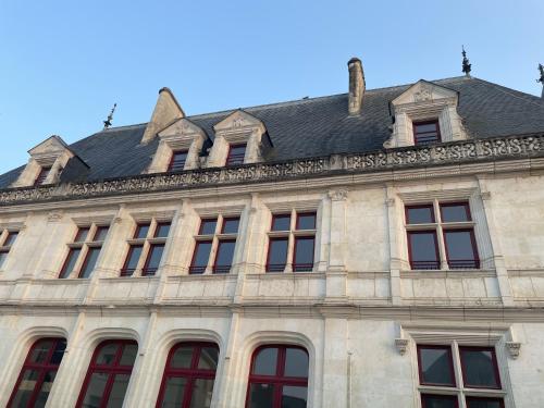 un bâtiment avec des fenêtres et un toit dans l'établissement Résidence du Palais, à Bourges