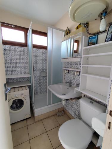 une salle de bain avec un lavabo et une machine à laver dans l'établissement Appartement face mer terrasse couverte parking, au Barcarès