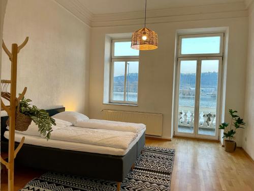 a bedroom with a bed and two windows at LaBed - Wohnen direkt an der Drosselgasse, stilvolle Ferienwohnung mit Rheinblick in Rüdesheim am Rhein