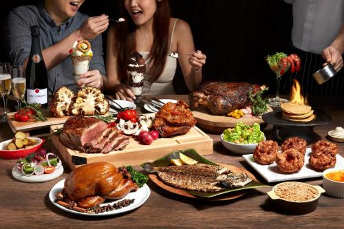a table topped with lots of different types of food at voco Orchard Singapore by IHG in Singapore