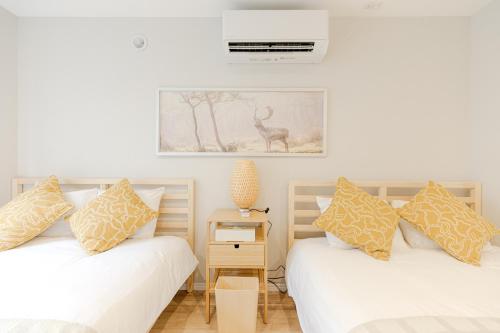 a bedroom with two beds and a picture on the wall at Mi-HOTEL UENO in Tokyo