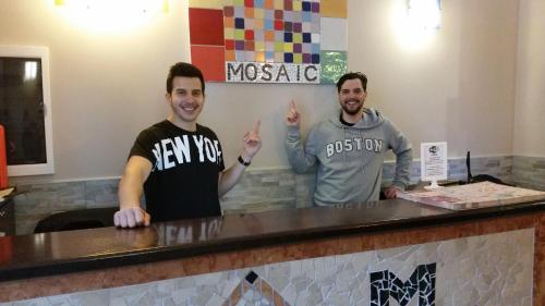 two men standing at a counter in a restaurant at Hostel Mosaic in Rome