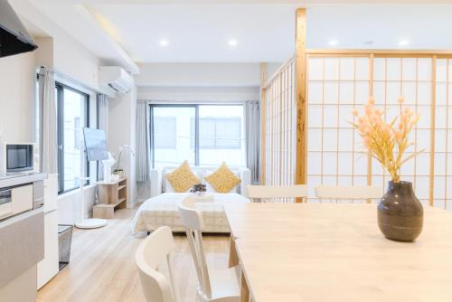 a room with a bed and a table and chairs at Mi-HOTEL UENO in Tokyo