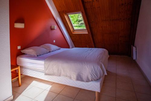 a bedroom with a bed in a room with a window at Village de vacances Le Serre de la Can in Saint-Germain-de-Calberte