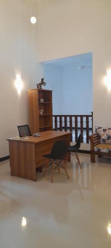a desk with a laptop and two chairs in a room at Airport A4 Travelers Lodge - Free Airport Pick Up & Drop 24HRS in Katunayake