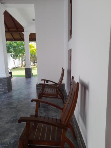 three rocking chairs sitting on the porch of a house at Airport A4 Travelers Lodge - Free Airport Pick Up & Drop 24HRS in Katunayake