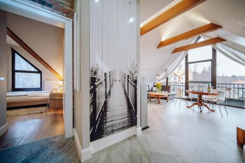 a room with a balcony with a bedroom and a table at Apartamentowiec Panorama Gór City Center Family&Pet-friendly in Szklarska Poręba