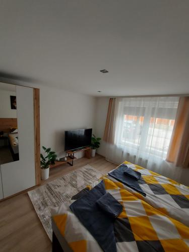 a bedroom with a bed and a flat screen tv at nani apartman in Vecsés