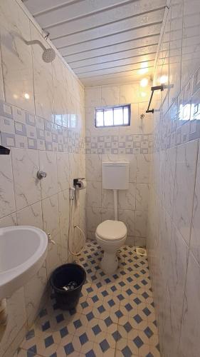 a bathroom with a white toilet and a sink at Roof Top House in Lamu