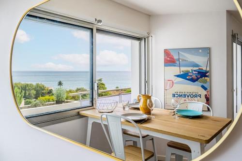 une salle à manger avec une table et une grande fenêtre dans l'établissement Le grand bleu, à La Ciotat