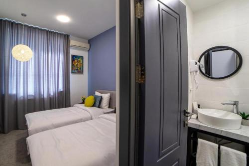 a bathroom with two beds and a sink and a mirror at Benefice Hotel Yerevan-通緝 in Yerevan