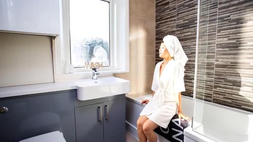 a woman in a towel standing in a bathroom at West Beck House - Newcastle 3 in North Shields