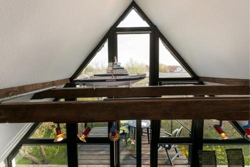 a view of a boat in a room with windows at RügenHerz DACHTRÄUME Atelierwohnung 1 - 4 Personen in Parchtitz