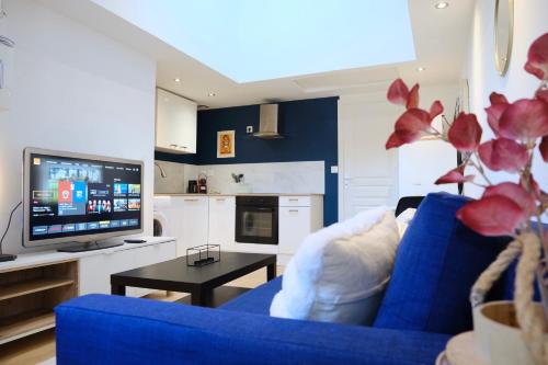 un salon avec un canapé bleu et une télévision dans l'établissement Your Home Loos 2 - Proche Lille, à Loos