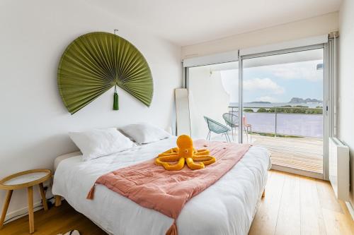 une chambre avec un grand lit et une grande fenêtre dans l'établissement Le grand bleu, à La Ciotat