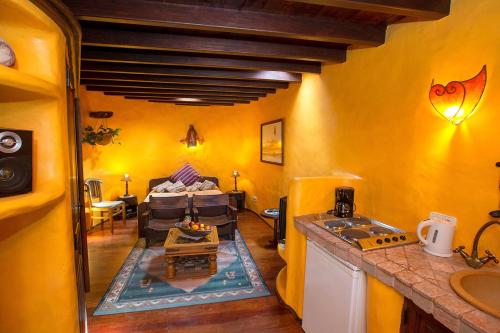 a kitchen with yellow walls and a living room with a couch at NIRO - Sauna, beheizter Pool, Billiard Tisch, Tischtennis in Tías