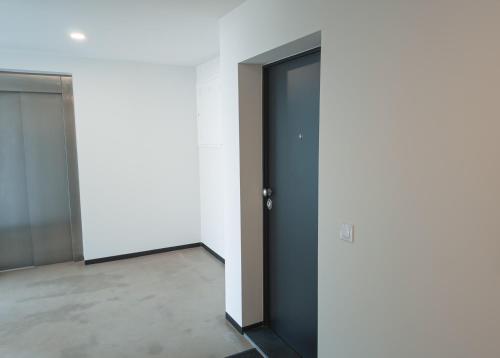 an empty room with two doors in a building at Flat with garage and balcony with view to a garden in Vila Nova de Gaia