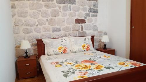 a bedroom with a bed with a stone wall at Apartments Popovic in Kotor