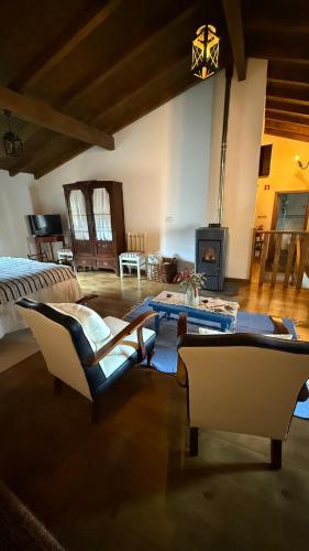 a living room with a bed and chairs and a table at LouzaNook - Casa do Moinho in Lousã