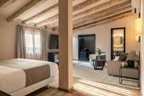 a bedroom with a bed and a living room at Hesperia Barcelona Barri Gòtic in Barcelona
