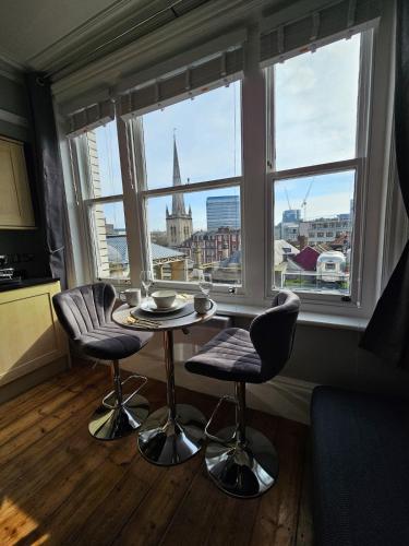 a table and two chairs in front of a window at City Centre Location on Corn Street studio in Bristol