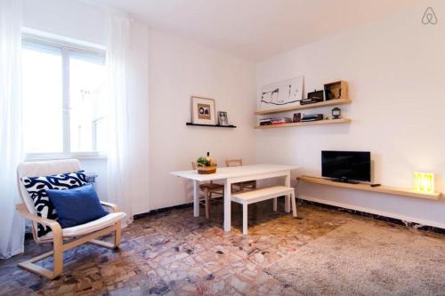 a living room with a table and a chair and a television at Casa Vacanze Via Marconi in Marotta