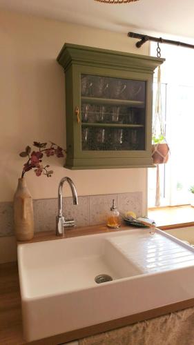 a kitchen sink with a green cabinet above it at A la LampePigeon, un gîte avec jardin et du calme, 3 min de la Ferté-sous-Jouarre, 42 min de Paris TER, 35 min de Disney, 10 min de l'A4 in Reuil-en-Brie
