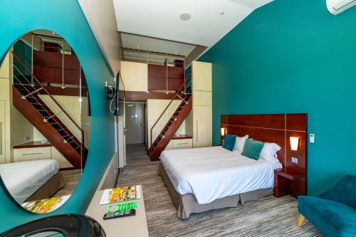 a room with two beds and a mirror at Hôtel du Casino de Capvern in Capvern