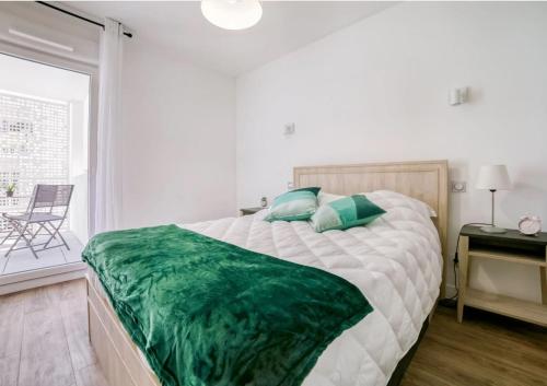 une chambre avec un grand lit avec une couverture verte dans l'établissement Résidence de Cannes La Bocca, à Cannes