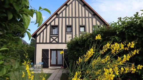 a house with yellow flowers in front of it at Maison paisible avec jardin à Houlgate in Houlgate