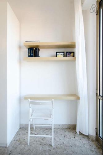 a white chair sitting in a room with a desk at Casa Vacanze Via Marconi in Marotta