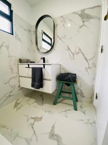 a white bathroom with a mirror and a stool at Dani House - Porto Moniz Escape in Porto Moniz