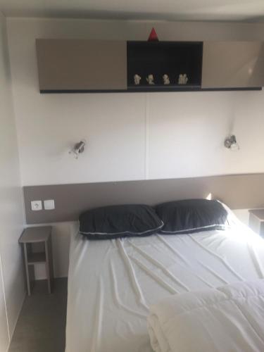 - une chambre avec un lit blanc et une étoile rouge au-dessus dans l'établissement k154 Charmettes, aux Mathes