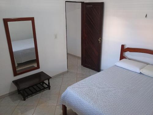 una camera da letto con un letto e uno specchio di Casa na praia de Touros a Touros