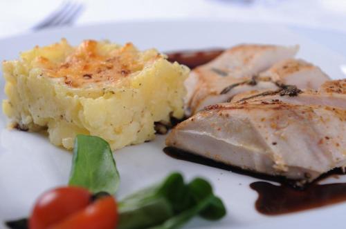a plate of food with meat and mashed potatoes and tomatoes at Hotel Berg in Staré Splavy